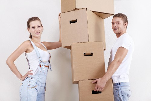 Removal staff carrying furniture through a residential property in Romford